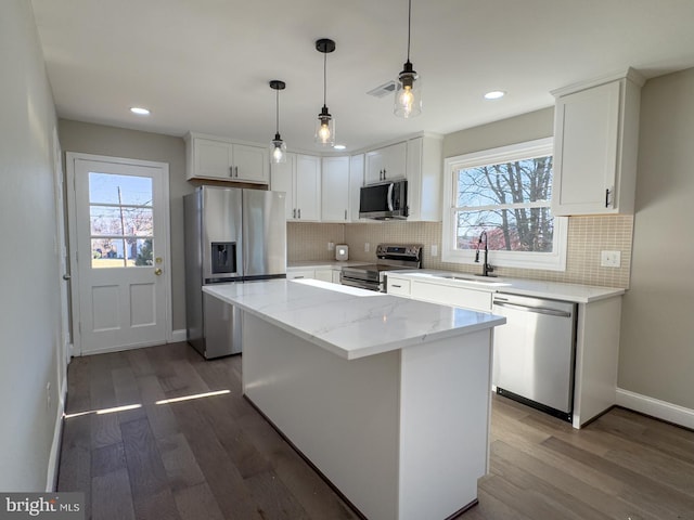 kitchen featuring white cabinets, dark hardwood / wood-style floors, a kitchen island, and appliances with stainless steel finishes