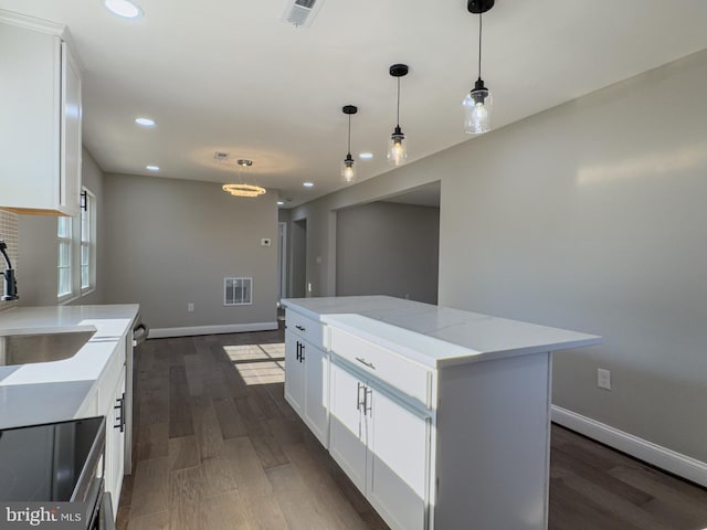 kitchen featuring a center island, white cabinetry, dark wood-type flooring, and sink