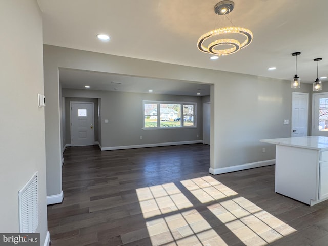 kitchen featuring pendant lighting, white cabinetry, dark wood-type flooring, and a chandelier