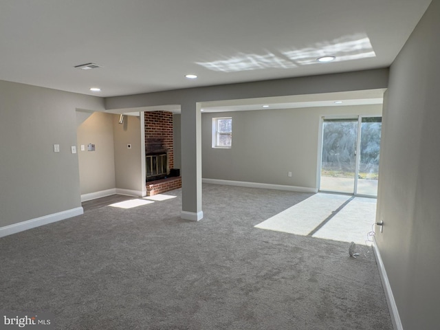 basement featuring carpet and a brick fireplace