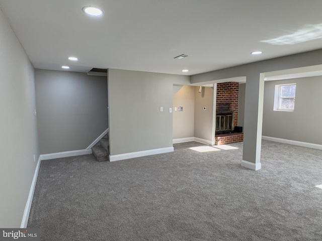 basement with carpet flooring and a brick fireplace