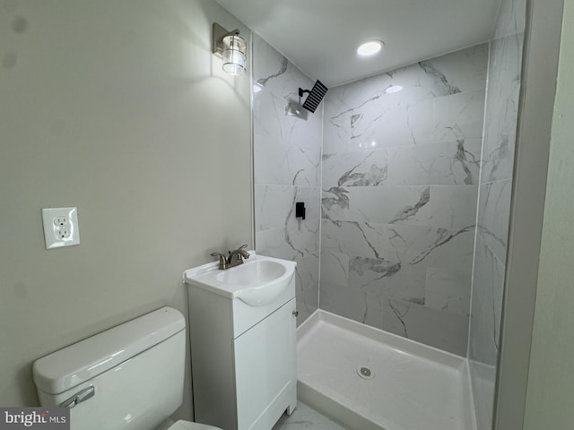 bathroom featuring tiled shower, vanity, and toilet