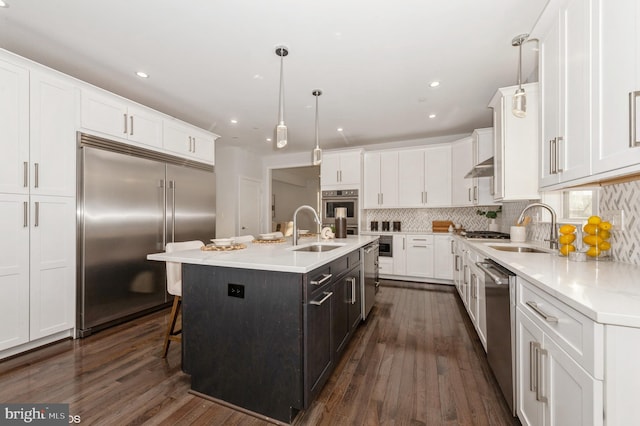 2418 Taney Rd, Baltimore, MD 21209 - kitchen with stainless steel appliances, a sink, white cabinetry, dark wood finished floors, and recessed lighting