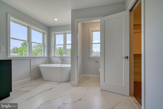 2418 Taney Rd, Baltimore, MD 21209 - bathroom featuring a freestanding bath, a spacious closet, marble finish flooring, baseboards, and recessed lighting