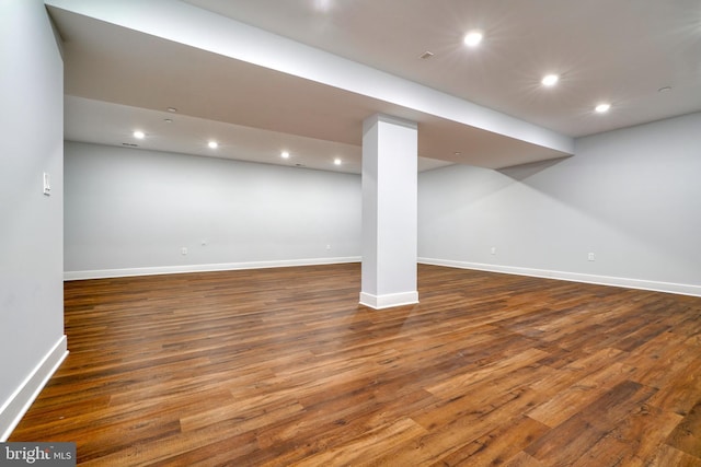 basement with dark hardwood / wood-style floors