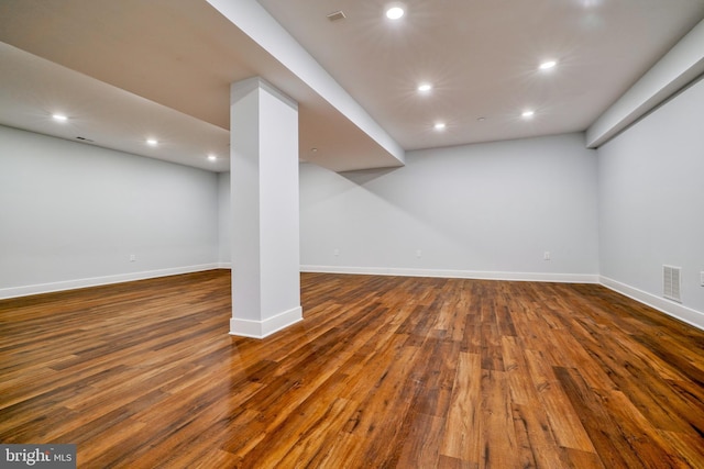 basement with dark hardwood / wood-style floors