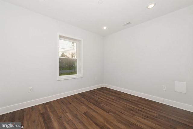 unfurnished room with dark wood-type flooring