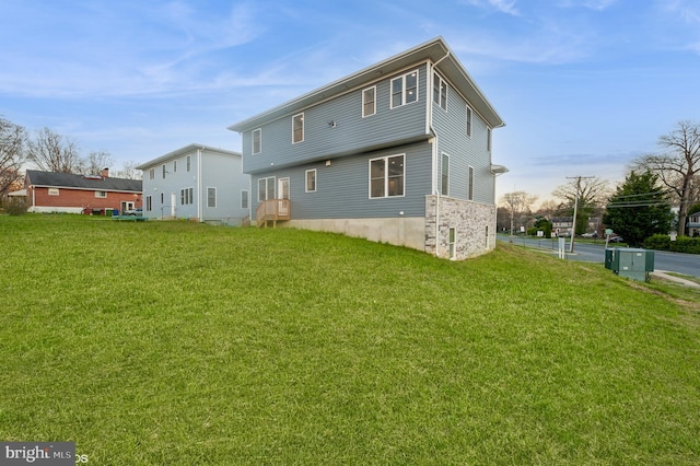 rear view of house featuring a lawn