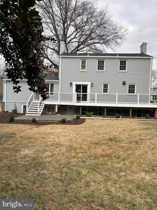 back of house featuring a lawn and a deck