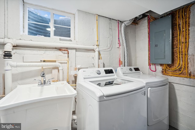 laundry room featuring washer and clothes dryer, sink, and electric panel