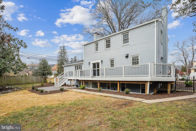 back of property with a lawn and a deck