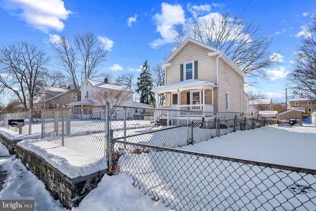 snow covered rear of property with a porch