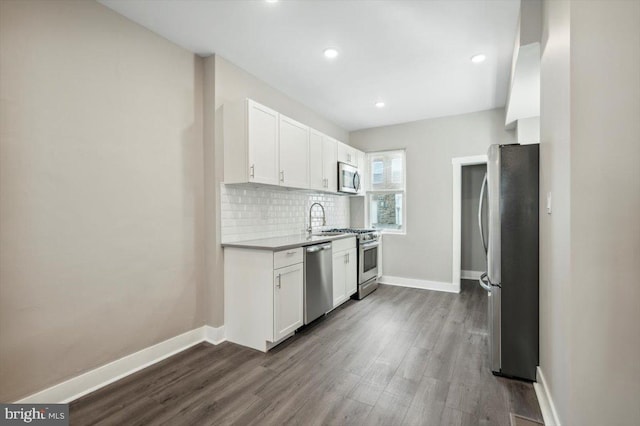 kitchen featuring backsplash, white cabinets, stainless steel appliances, and dark hardwood / wood-style floors