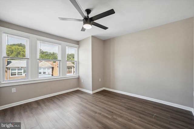 empty room with ceiling fan and dark hardwood / wood-style flooring