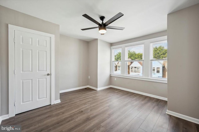 empty room featuring ceiling fan and dark hardwood / wood-style floors