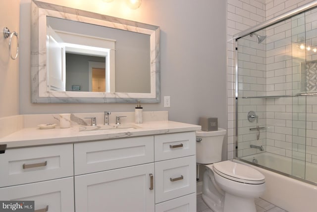 full bathroom featuring shower / bath combination with glass door, tile patterned floors, vanity, and toilet