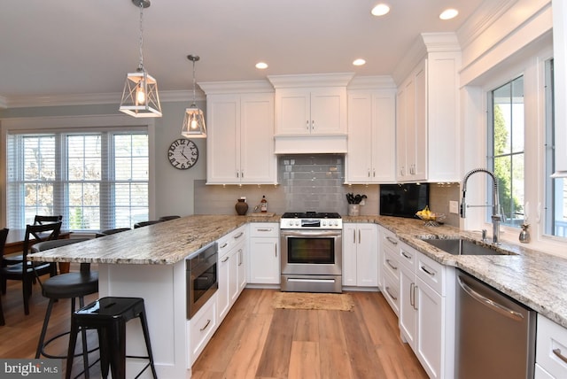 kitchen featuring a healthy amount of sunlight, sink, white cabinets, and stainless steel appliances