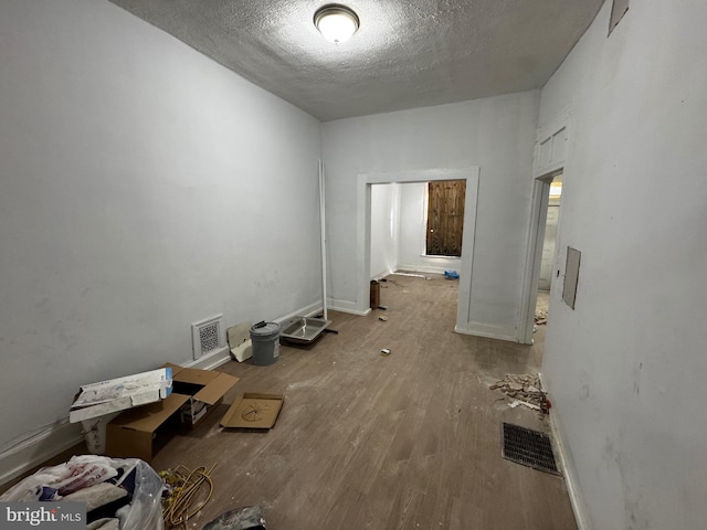 interior space with a textured ceiling and hardwood / wood-style flooring