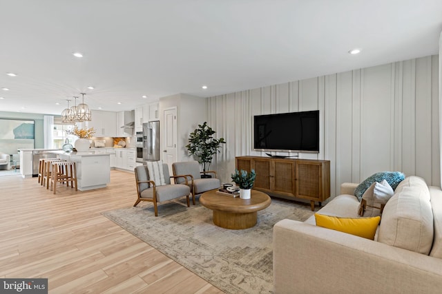 living room with light hardwood / wood-style flooring and an inviting chandelier