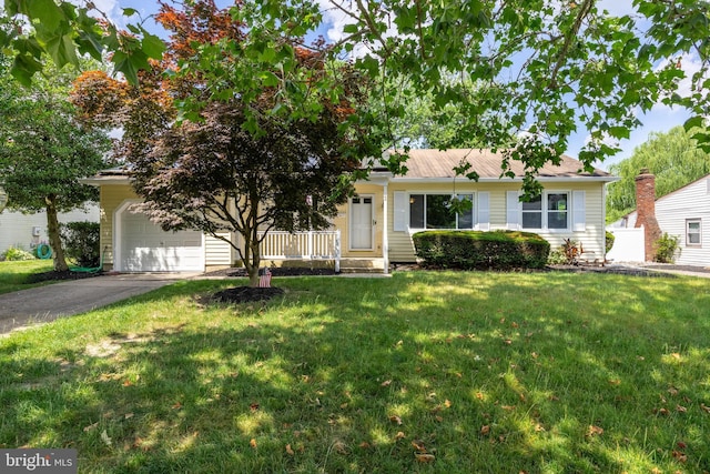 view of front of property featuring a front yard, a garage, and covered porch