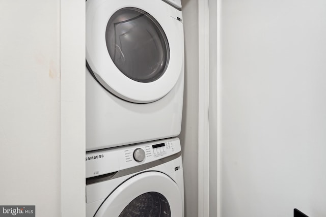 clothes washing area featuring stacked washer / dryer