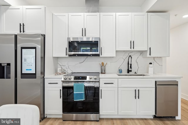 kitchen featuring white cabinetry, light wood-type flooring, and appliances with stainless steel finishes