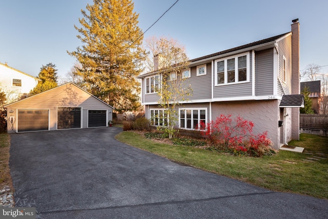 view of front facade featuring an outbuilding, a garage, and a front yard