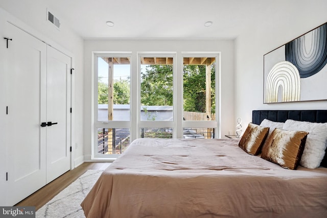 bedroom with light hardwood / wood-style floors and multiple windows