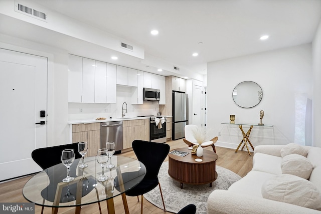 living room with sink and light hardwood / wood-style floors