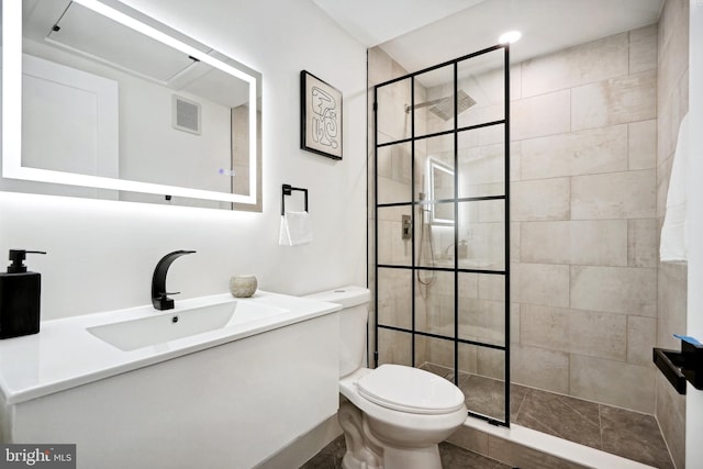 bathroom featuring tiled shower, vanity, and toilet