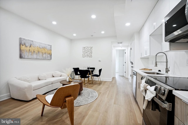 living room featuring light wood-type flooring and sink