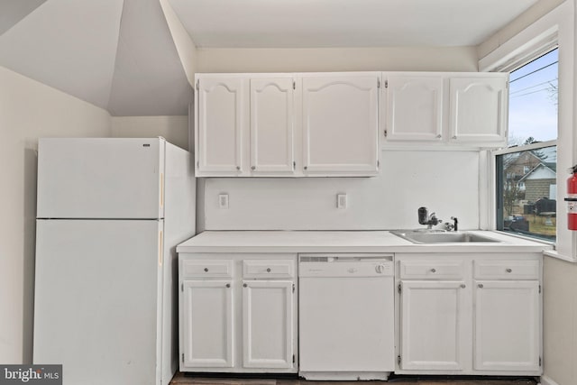 kitchen featuring lofted ceiling, sink, white cabinets, and white appliances