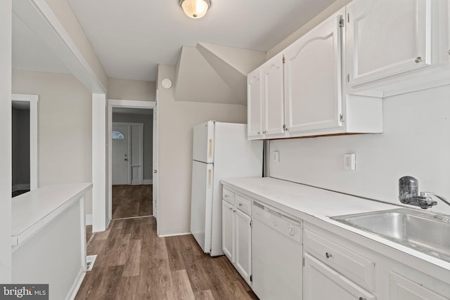 kitchen featuring sink, white cabinets, white appliances, and hardwood / wood-style flooring