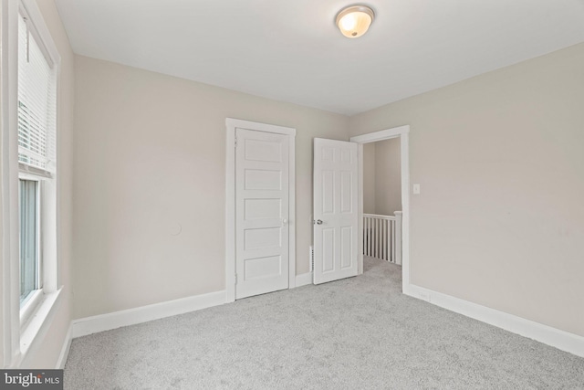 unfurnished room featuring light colored carpet and a wealth of natural light