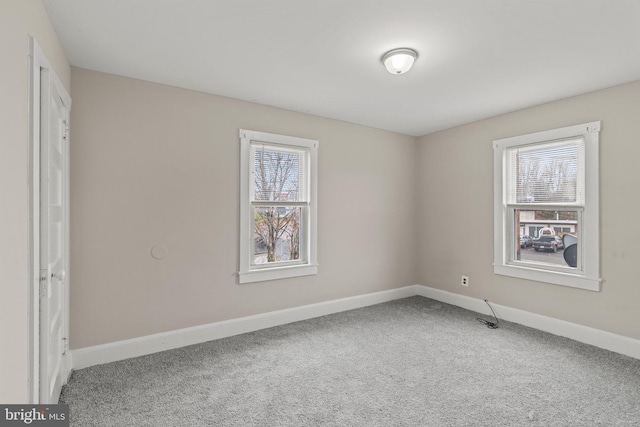 carpeted spare room featuring a healthy amount of sunlight