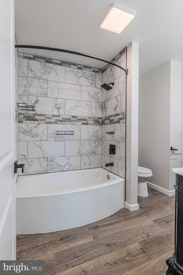 full bathroom featuring wood-type flooring, vanity, toilet, and tiled shower / bath