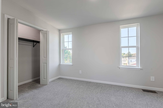 unfurnished bedroom featuring carpet, a closet, and multiple windows