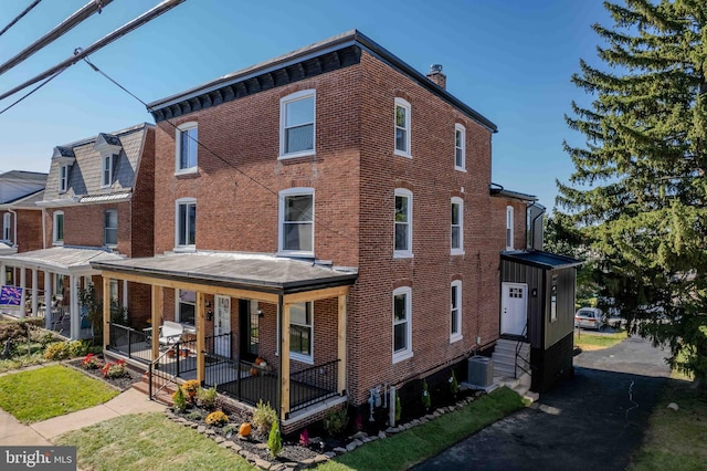 back of house with central air condition unit and a porch