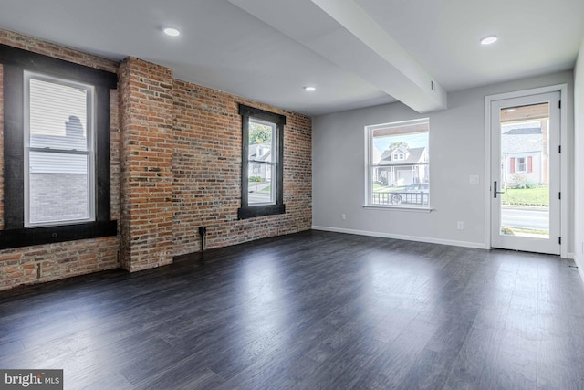 unfurnished living room featuring dark hardwood / wood-style floors and brick wall