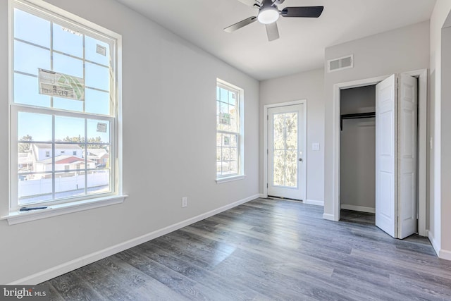 unfurnished bedroom with ceiling fan, dark wood-type flooring, and a closet