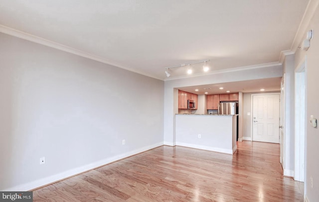 unfurnished living room with light wood-type flooring, track lighting, and crown molding