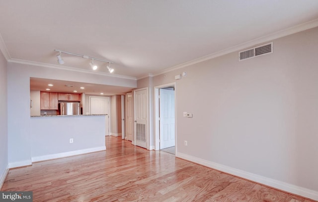 unfurnished living room with ornamental molding, rail lighting, and light hardwood / wood-style flooring