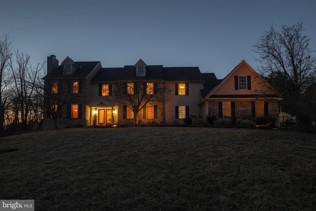 colonial-style house with a lawn