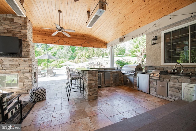 view of patio / terrace featuring ceiling fan, area for grilling, and an outdoor wet bar