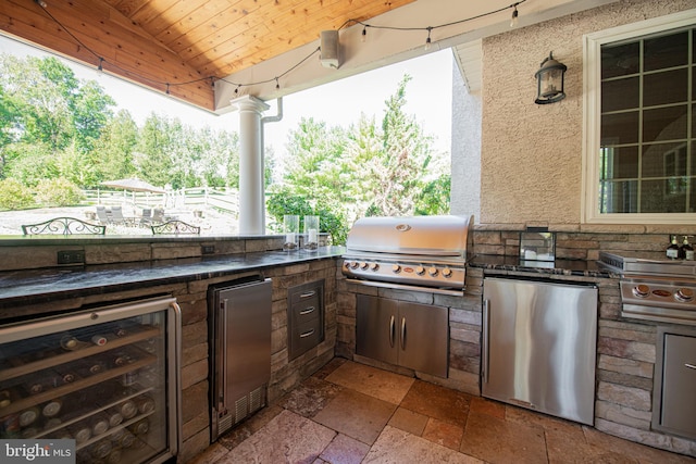 view of patio / terrace featuring wine cooler, grilling area, and an outdoor kitchen