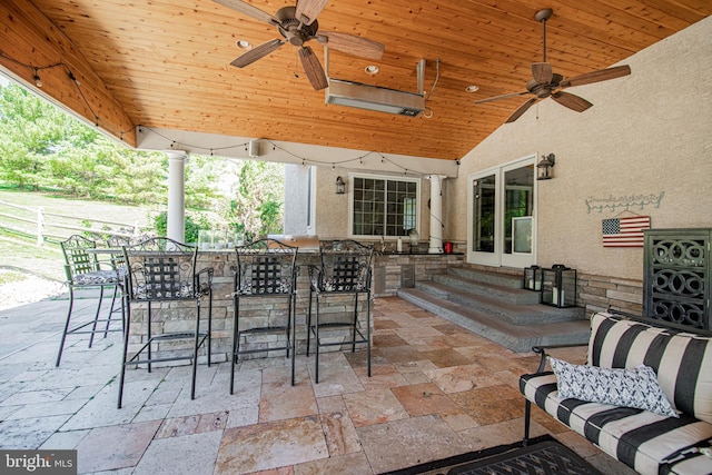 view of patio featuring exterior bar and ceiling fan