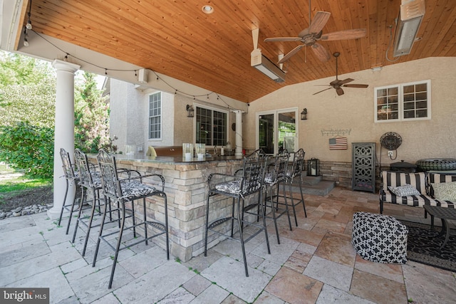 view of patio / terrace with ceiling fan and a bar