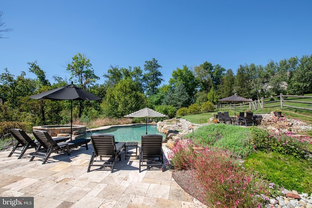 view of swimming pool featuring a patio and a hot tub