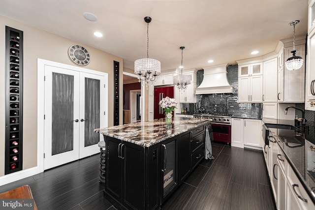 kitchen with premium range hood, pendant lighting, a kitchen island, and french doors