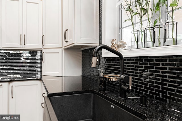 kitchen with sink, tasteful backsplash, and white cabinetry